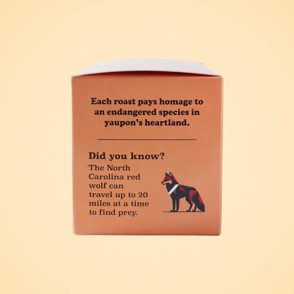 Goldholly Red Wolf Dark Roast box side panel highlighting North Carolina red wolf conservation with geometric wolf illustration and educational facts about endangered species protection through sustainable business.