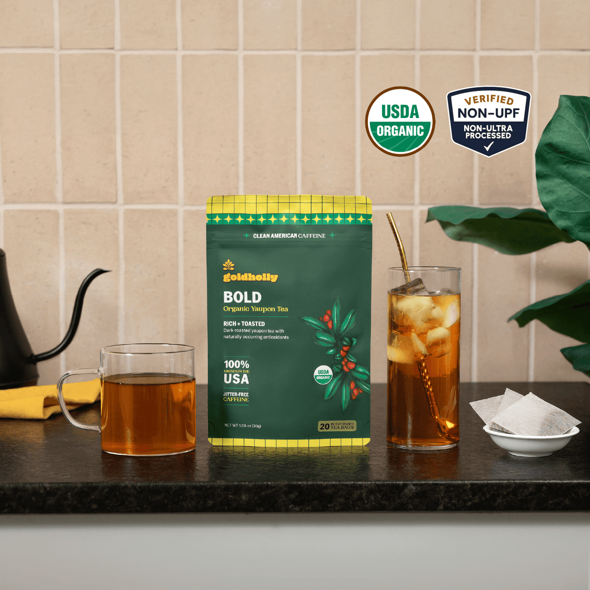 Goldholly Bold organic yaupon tea pouch on a kitchen counter with a mug of hot tea and a glass of iced tea; USDA Organic, Verified Non-UPF--1