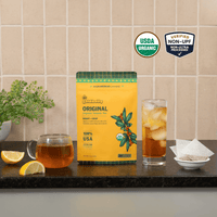 Goldholly Original organic yaupon tea pouch on a kitchen counter with a mug of hot tea and a glass of iced tea; USDA Organic, Verified Non-UPF--1